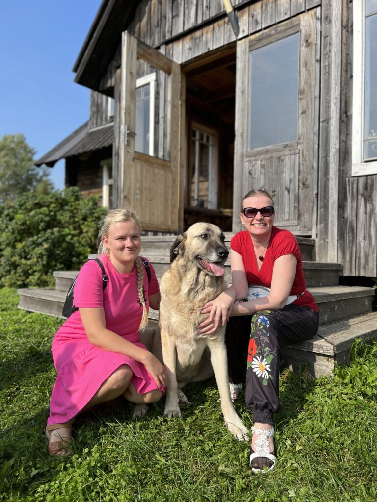 Maarja-Liis Orgmets ja Helen Künnap istuvad suure koeraga talutrepil. 