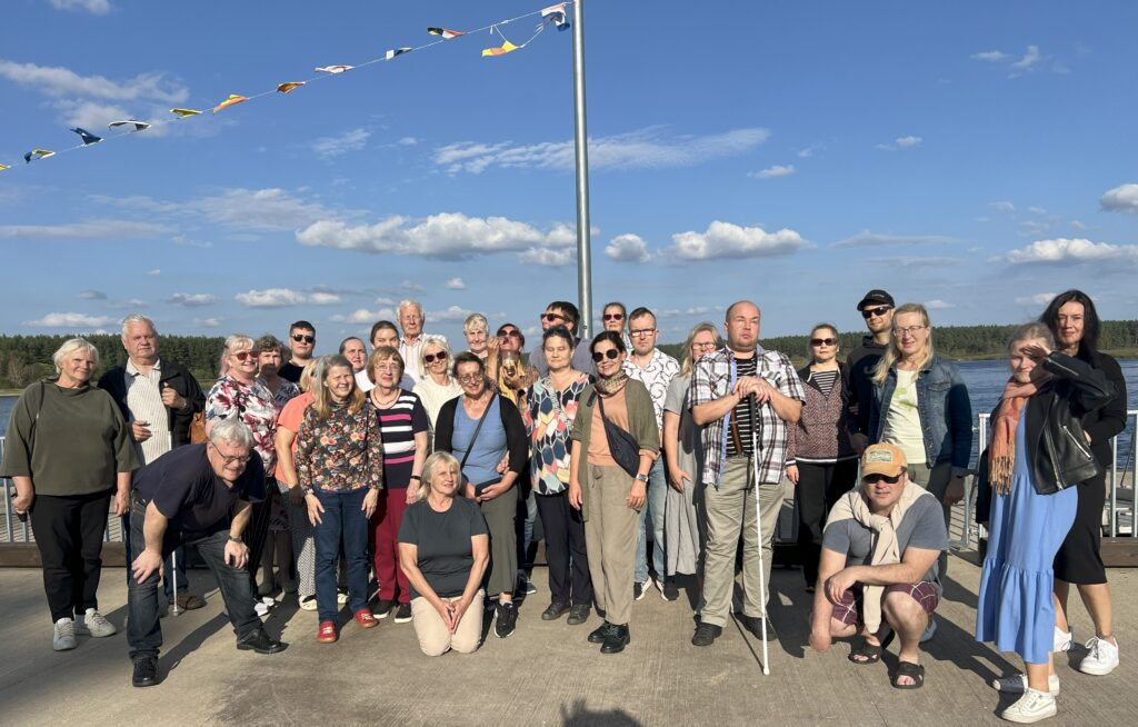 Grupp inimesi sinise taeva all poseerimas.